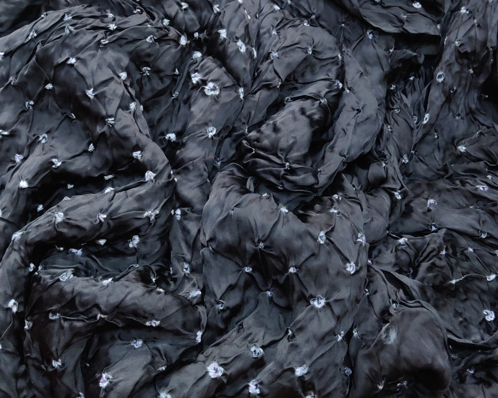 Close-up of black fabric with small white flowers embedded