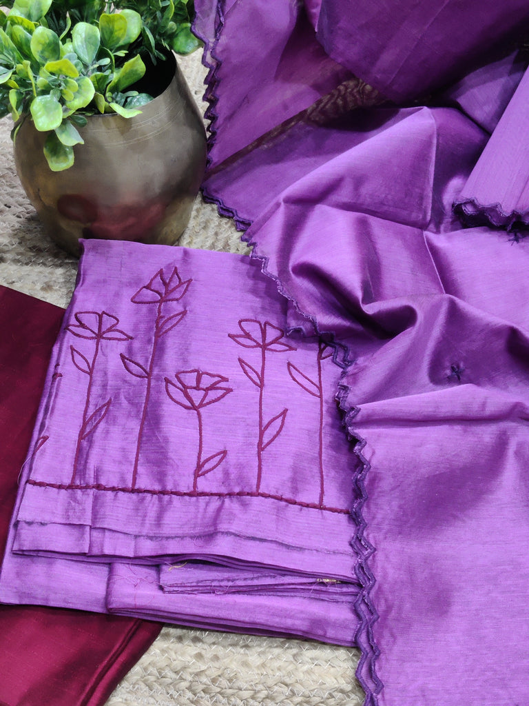 Purple fabric with floral embroidery on a textured surface