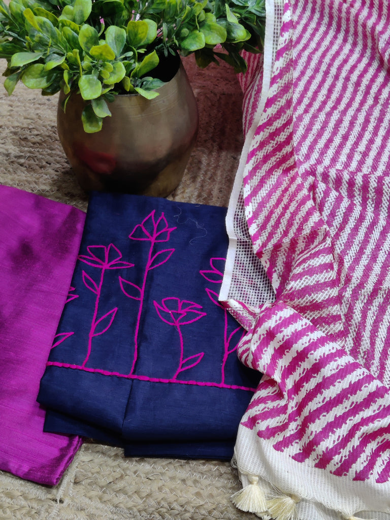Textiles with floral embroidery and a striped pattern on a textured surface.