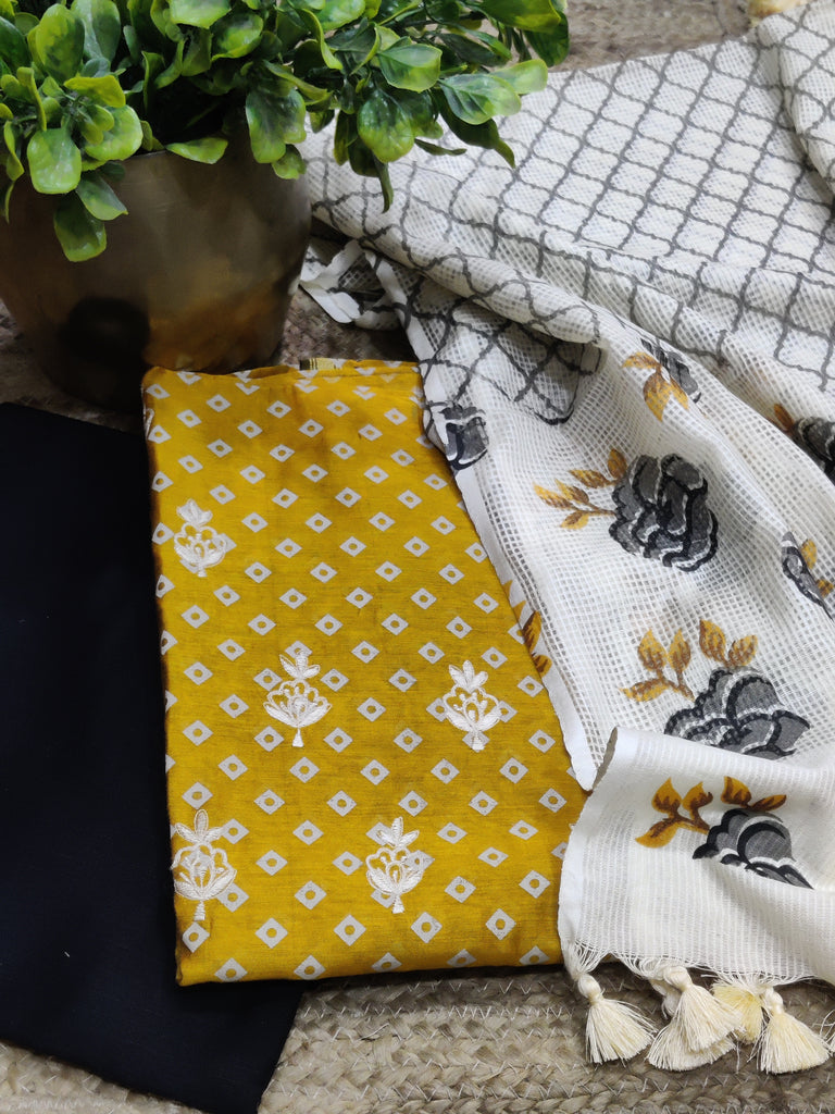 Yellow fabric with white patterns, gray and white checkered fabric, and white fabric with black floral patterns on a textured surface.