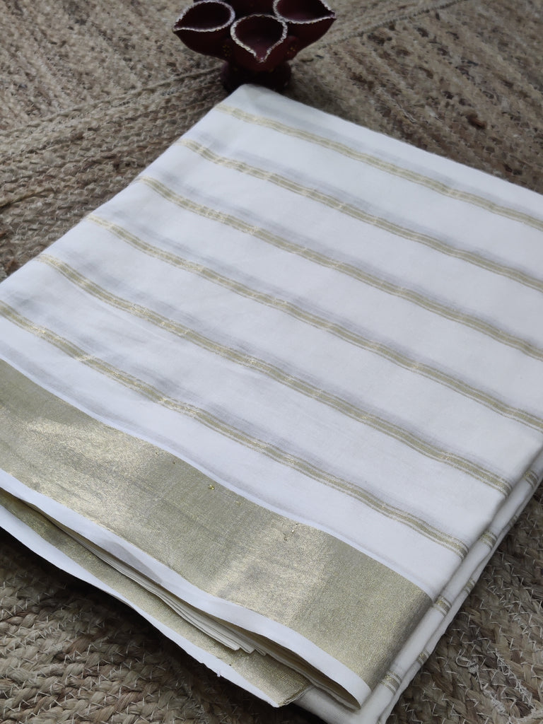 Folded white fabric with gold stripes on a textured surface