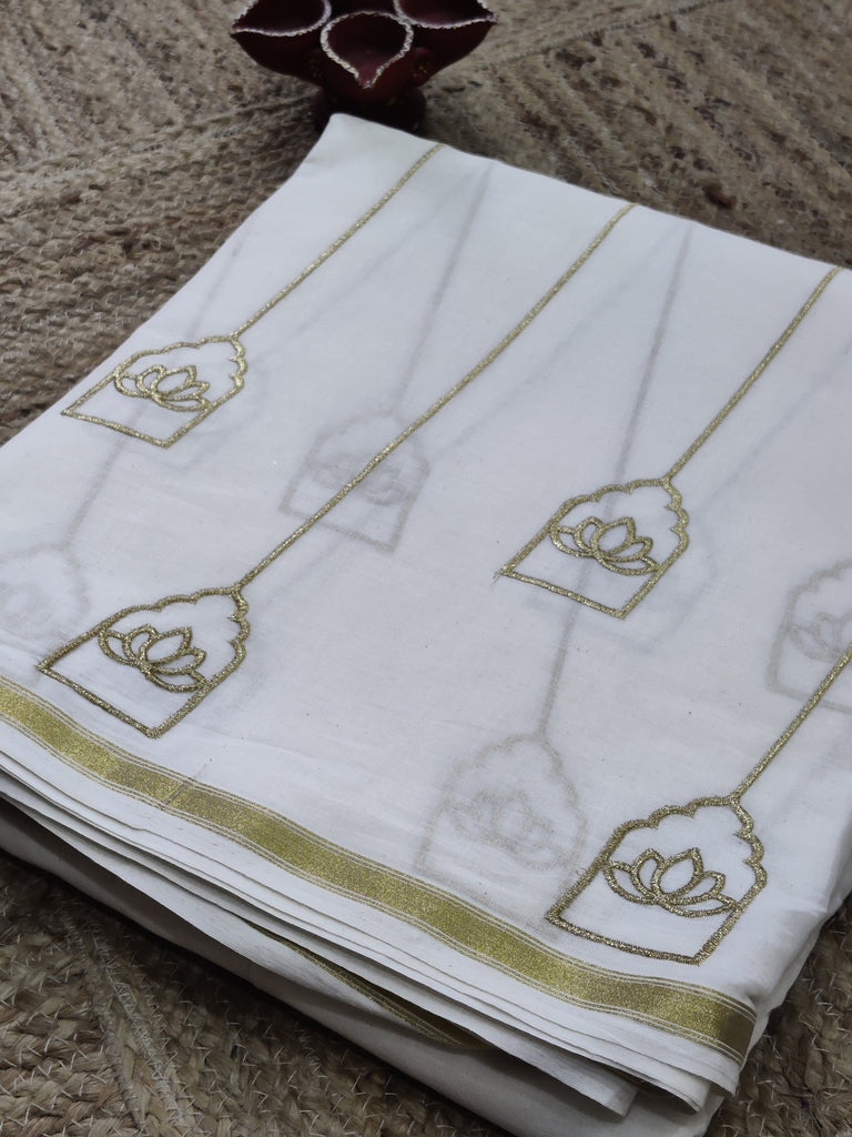 White towel with gold embroidery on a textured surface