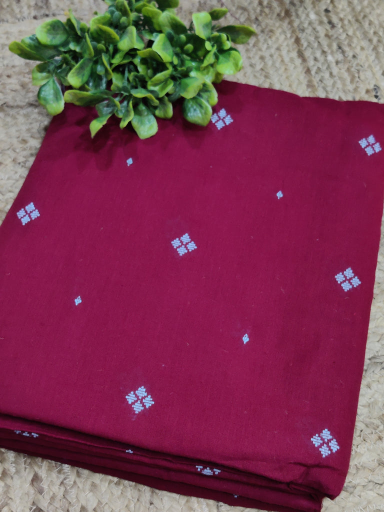 Maroon fabric with white patterns on a textured surface