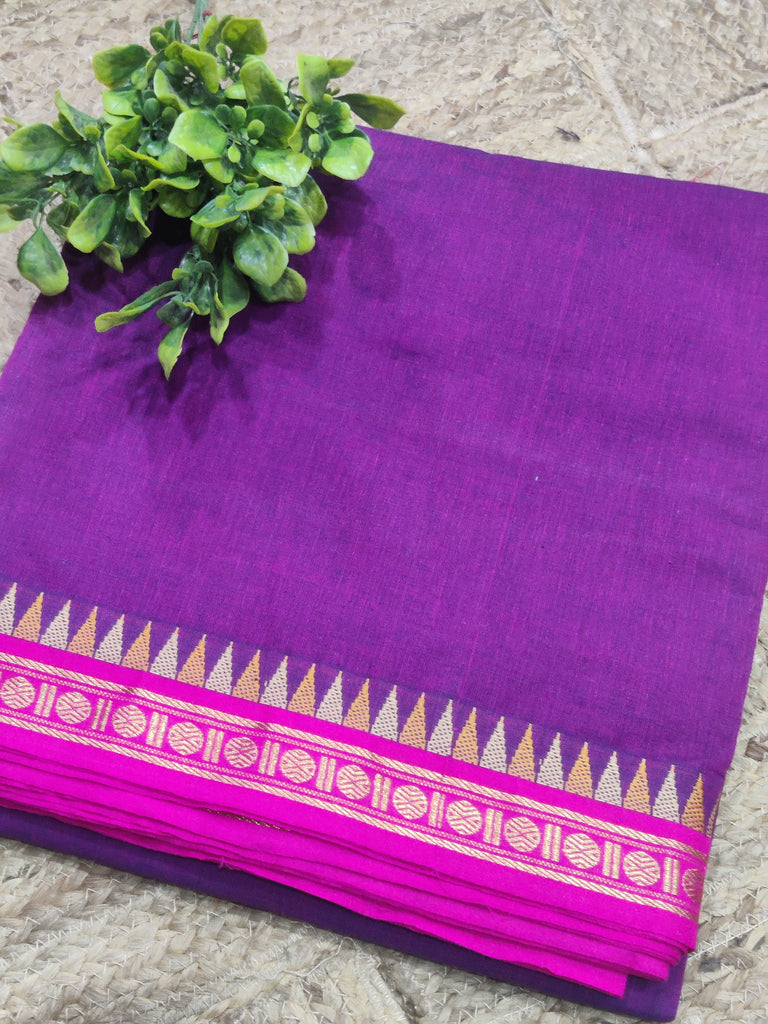 Purple saree with pink border on a stone surface