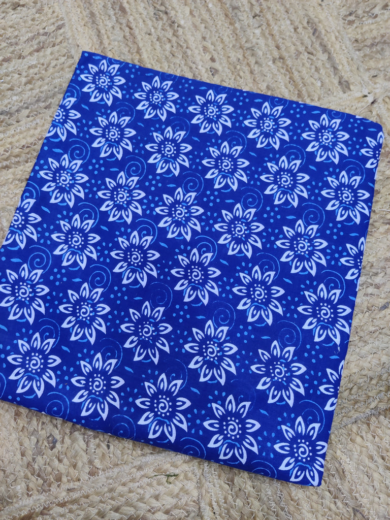 Blue fabric with white floral patterns on a textured surface