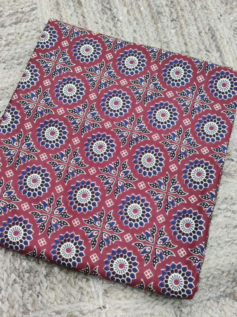 Fabric with a red and blue geometric pattern on a textured surface
