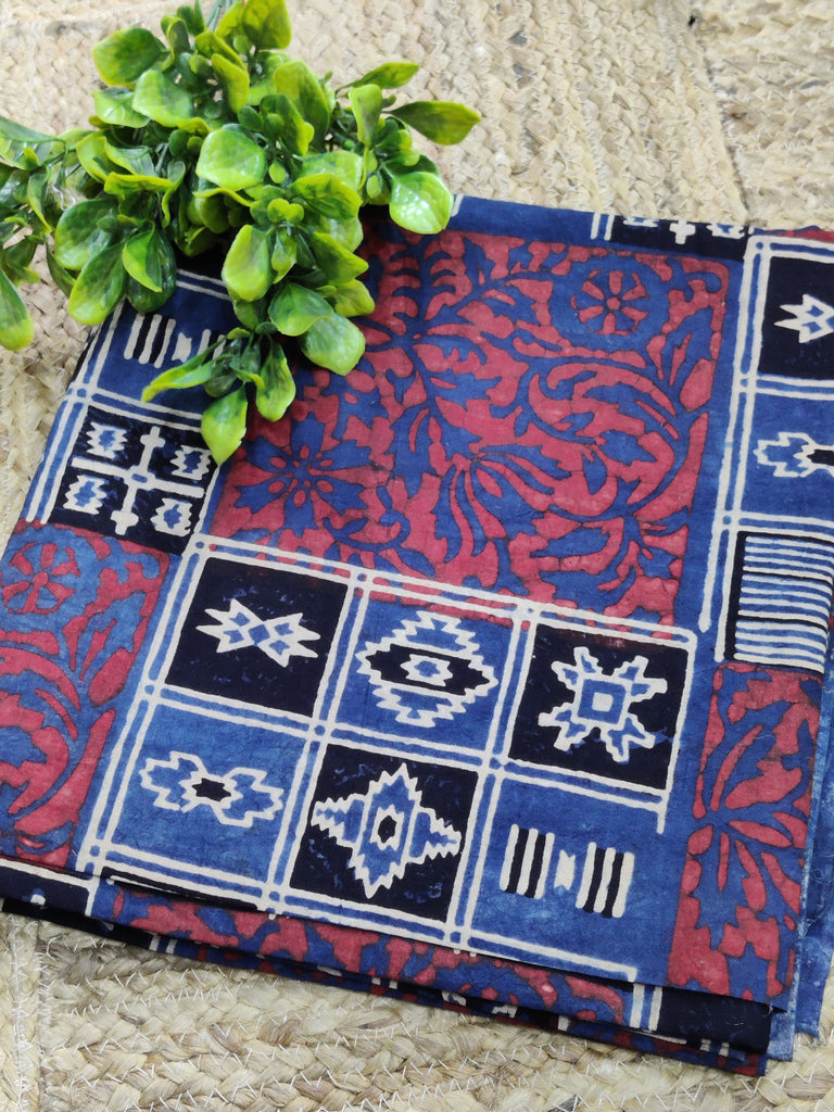 Blue and red patterned fabric with geometric designs on a stone surface.