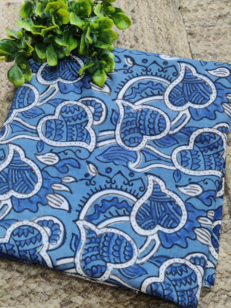 Blue fabric with white floral patterns on a stone surface