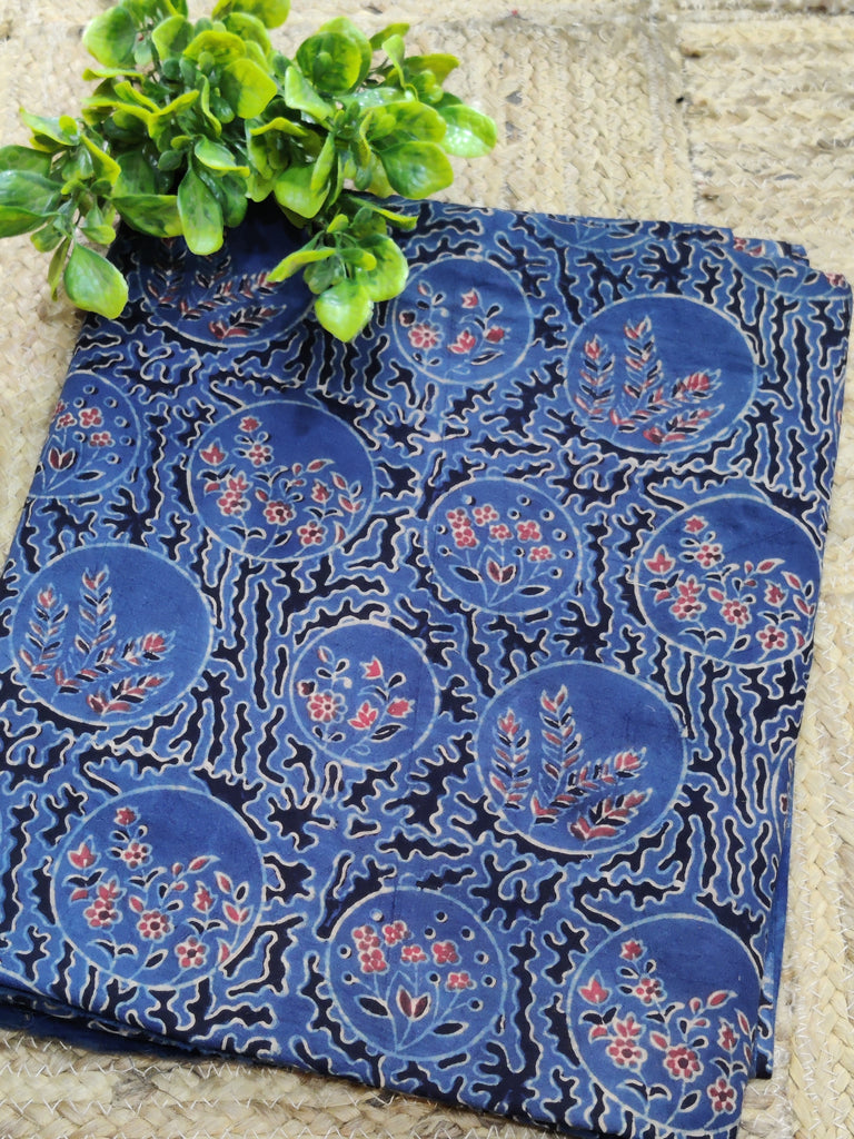 Blue patterned fabric with floral designs on a stone surface