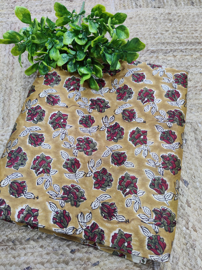 Fabric with floral pattern on a textured surface with green leaves.