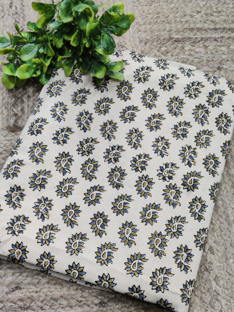 Fabric with a floral pattern on a stone surface with green leaves.