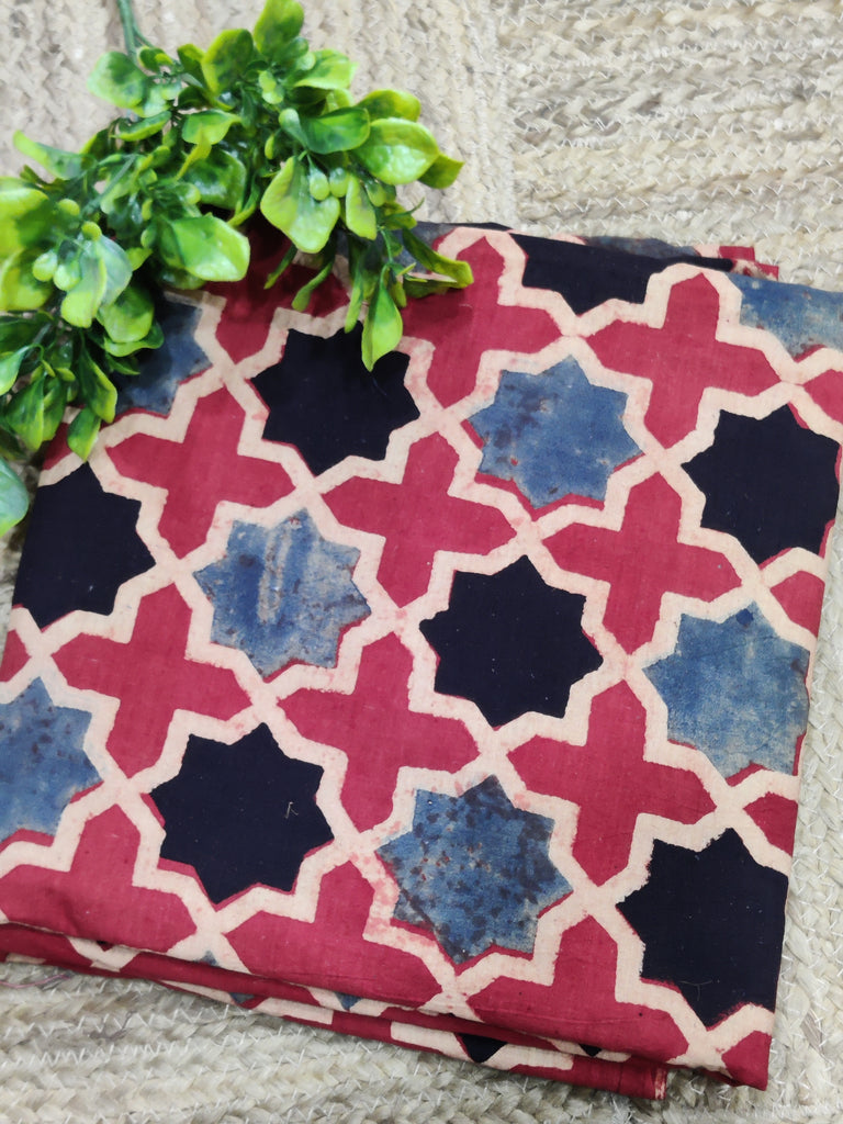 Fabric with geometric pattern on a stone surface with greenery