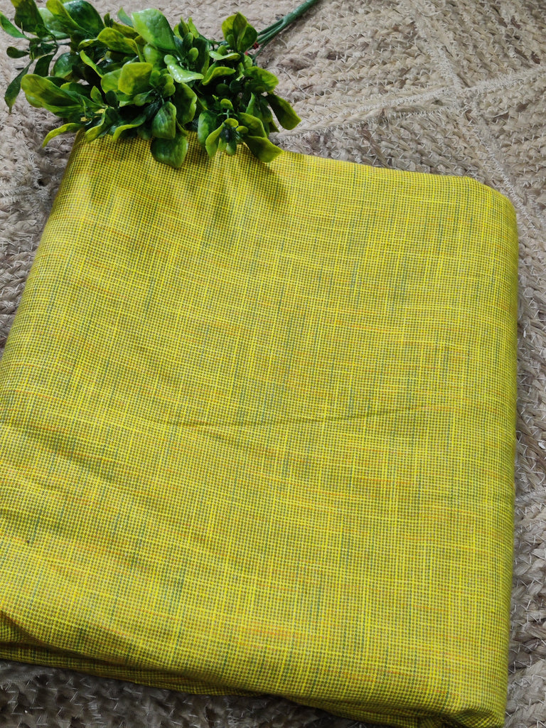 Folded yellow fabric with a subtle pattern on a textured surface