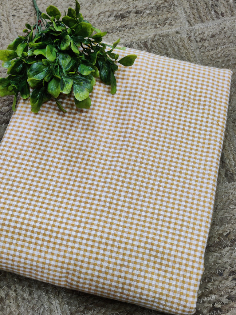 Checkered fabric with a plant on a stone surface