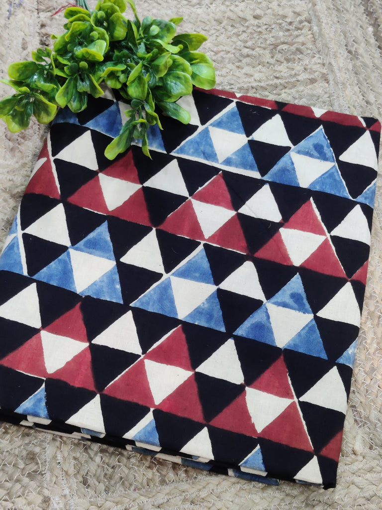 Fabric with a geometric triangle pattern in red, blue, and white on a textured surface.