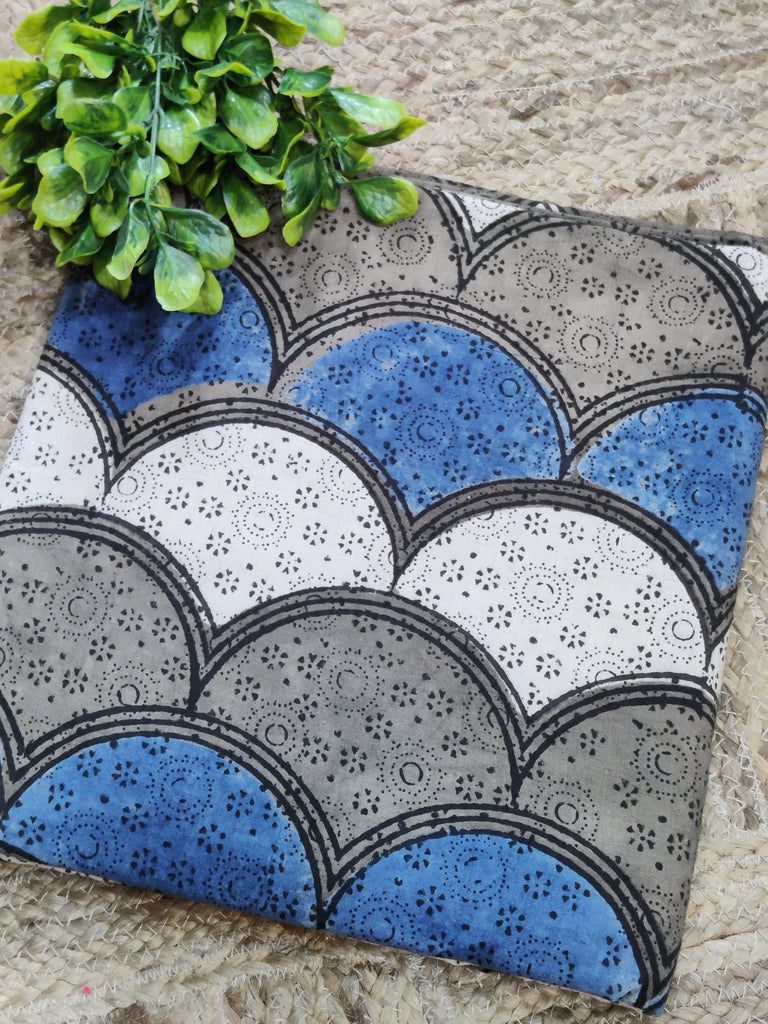 Decorative mat with blue, gray, and white pattern on a textured surface.
