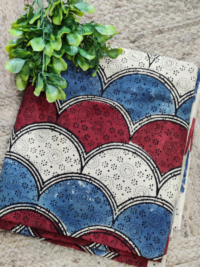 Decorative fabric with red, blue, and white pattern on a textured surface.